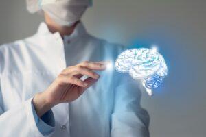 Female doctor touches virtual Brain in hand. Blurred photo, handrawn human organ, highlighted blue as symbol of recovery.