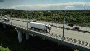 Long distance truck freight. Big lorry cargo transportation drone view from above.