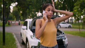 Worried African American woman talking mobile phone smartphone call breaking accident car automobile auto transport female girl stress service crash businesswoman explain vehicle business city outside.