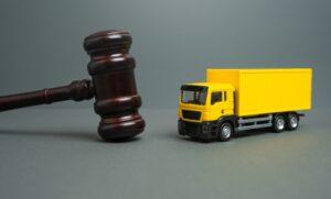Yellow truck and judge's gavel. Court case. New laws and acts. Restrictions and regulations. Bankruptcy.
