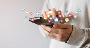 adult man hand hold smartphone and use social media network application to check new feedback or interactive with people or friend by reply chat or send emoticon for react feeling and moment concept.