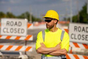 No trespassing. Construction worker with outstretched hand showing stop gesture warning. Stop sign in hands of worker.