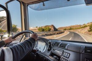Truck driver driving on the highway, seen from inside the cab.